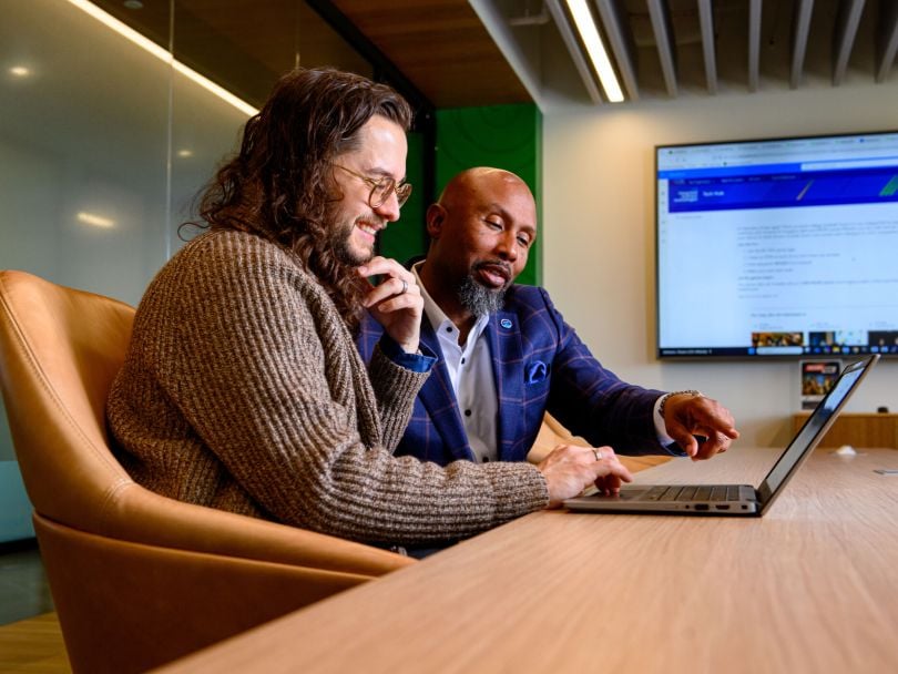 Two Cox Enterprises team members work on a project together in the company's office